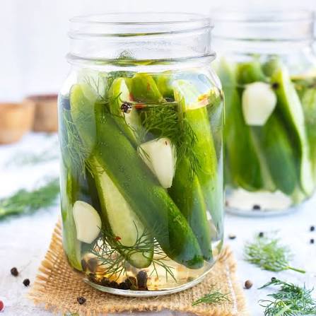 Homemade kosher pickles in a jar with garlic and dill
